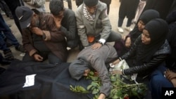 Palestinians mourn relatives killed in the Israeli bombardment of the Gaza Strip outside a morgue in Khan Younis on Dec. 24, 2023.