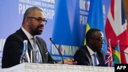 Waziri wa Mambo ya Ndani wa Uingereza James Cleverly (kushoto) na Waziri wa Mambo ya Nje wa Rwanda Vincent Biruta, baada ya kutia saini mkataba mpya huko Kigali Desemba 5, 2023. Picha na Ben Birchall / POOL / AFP.