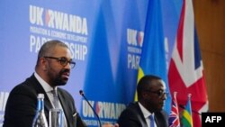 Waziri wa Mambo ya Ndani wa Uingereza James Cleverly (kushoto) na Waziri wa Mambo ya Nje wa Rwanda Vincent Biruta baada ya kutia saini mkataba mpya huko Kigali Desemba 5, 2023. Picha na Ben Birchall / POOL / AFP.