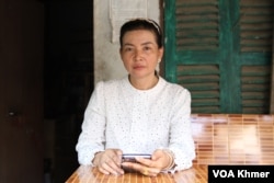 អ្នកស្រី ឡង់ សូដានី ភរិយារបស់លោក ខឹម ចាន់ វណ្ណៈ អង្គុយខាងមុខបន្ទប់ស្នាក់នៅក្នុងសង្កាត់និងមើលរូបស្វាមីដែលកំពុងជាប់ពន្ធនាគារ ក្នុងសង្កាត់កាកាបទី១ ខណ្ឌពោធិ៍សែនជ័យ កាលពីថ្ងៃទី៨ ខែកុម្ភៈ ឆ្នាំ២០២៤។ (លាស់ លីបលីប/វីអូអេ)