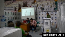 Petugas KPU dan para saksi partai melakukan rekapitulasi hasil tabulasi di tingkat kecamatan di Jakarta pada 16 Februari 2024. (Foto: AFP/Bay Ismoyo)