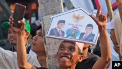 Pendukung calon presiden Anies Baswedan dan pasangannya Muhaimin Iskandar bersorak menunggu kedatangan pasangan tersebut untuk mendaftarkan nama mereka untuk mencalonkan diri pada pemilu tahun depan di gedung KPU Jakarta, 19 Oktober 2023. (Foto: AP )