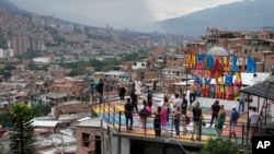 FILE - Tourists take photos in the Comuna 13 neighborhood of Medellin, Colombia, Feb. 2, 2024. 