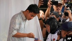 نائب صدارت کے امیدوارووٹ ڈالنے کے لیے اپنی انگلی پر سیاہی لگوا رہے ہیں۔