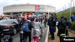 Foto ilustrasi yang menunjukkan sejumlah penumpang berjalan dengan koper mereka di Terminal 1 di Bandara Charles de Gaulle di Roissy, Paris, pada 23 Maret 2023. (Foto: Reuters/Lucien Libert)