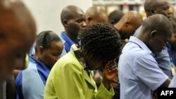 Wafanyikazi wa duka la Nakumatt wakisali kuadhimisha kumbukumbu ya mwaka wa pili wa shambulio la jumba la maduka la Westgate huko Nairobi, Septemba 21 2015. Picha na SIMON MAINA / AFP. 