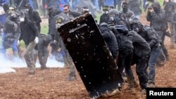 Protesters attend a demonstration called by the collective 'Bassines Non Merci' against the 'basins' on the construction site of new water storage infrastructure for agricultural irrigation in western France, in Sainte-Soline, France, March 25, 2023. 