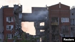 A firefighter works at a site of an apartment building hit by a Russian missile strike in the city of Dnipro, Ukraine, June 28, 2024.