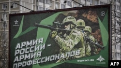 FILE - A photograph taken Oct. 24, 2022 shows a poster displaying Russian soldiers with a slogan reading 'Army of Russia - Army of professionals' decorating a street in Moscow.