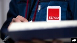 FILE - Logo Tokyo Electric Power Co. (TEPCO) terlihat pada seragam karyawan di pembangkit listrik tenaga nuklir Fukushima Dai-ichi di Okuma, prefektur Fukushima, Jepang, 23 Februari 2017. (Tomohiro Ohsumi/Pool Photo via AP)