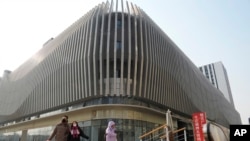 Sejumlah pejalan kaki melewati kompleks komersial Evergrande di Beijing, 29 Januari 2024. Dalam laporan yang dirilis Jumat (2/2), IMF memproyeksikan pertumbuhan ekonomi China akan melambat menjadi 4,6% tahun ini, dari pertumbuhan 5,2% pada 2022. (Foto: Ng Han Guan/AP Photo)