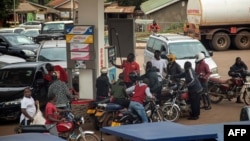 Waendesha bodaboda wakisubiri kujaza mafuta katika kituo cha mafuta huko Kampala Januari 19, 2022. Picha na Badru KATUMBA/AFP.