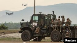 FILE - U.S. troops observe as V-22 Osprey aircraft are flown during the annual joint military exercises between U.S. and Philippine troops at a naval base in San Antonio, Zambales province, Philippines, April 26, 2023.