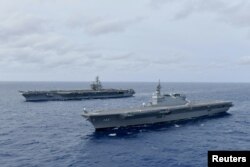 미 항공모함 로널드 레이건함(왼쪽)과 일본 해상자위대 헬기항모 이즈모함이 남중국해에서 항해하고 있다. (자료사진)