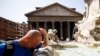 Seorang pria mendinginkan diri di air mancur dekat Pantheon, saat gelombang panas melanda Italia, di Roma, 19 Juli 2023. (Foto: Reuters)