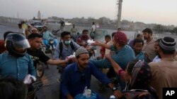 Para relawan membagikan makanan berbuka puasa di jalanan kota Karachi, di Pakistan (AP/Fareed Khan)