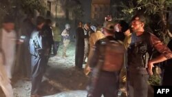 Petugas keamanan berkumpul di lokasi setelah beberapa ledakan yang disebabkan oleh kebakaran di gudang amunisi di kantor polisi Pakistan di Kabal, di Lembah Swat, pada 24 April 2023. (Foto: AFP)