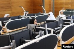 Qatari diplomats work inside an operation room set up to coordinate the truce and release of hostages between Israel and the Palestinian Islamist group Hamas, at the National Command Center in Doha, Nov. 26, 2023.