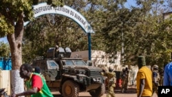 FILE - Burkina Faso mutinous soldiers guard the entrance of the national television station in Ouagadougou, Jan. 24, 2022. Human Rights Watch has criticized the country for omitting human rights abuses in a report to an African human rights commission.