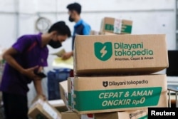 Karyawan mengemas barang di gudang unit e-commerce Goto Tokopedia di Jakarta, 31 Agustus 2022. (REUTERS/Ajeng Dinar Ulfiana)