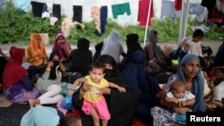 Pengungsi Rohingya beristirahat di gudang pelabuhan yang digunakan sebagai tempat penampungan sementara di Sabang, provinsi Aceh, 7 Desember 2023. (REUTERS/Riska Munawarah)