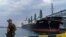 FILE - A security officer stands next to the ship Navi-Star loaded with grain as it waits to sail to sail from the Odesa Sea Port, in Odesa, Ukraine, on July 29, 2022.