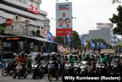 Masyarakat berjalan melewati baliho Menteri Pertahanan dan calon Presiden Prabowo Subianto dan pasangannya Gibran Rakabuming Raka di Jakarta, 12 Januari 2024. (Foto: REUTERS/Willy Kurniawan)