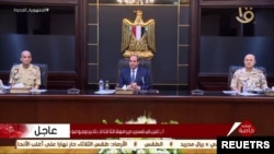 የግብፅ ፕሬዚደንት አብደል ፋታህ አል-ሲሲ ትናንት ማምሻውን ከግብጽ ከፍተኛ ወታደራዊ ም/ቤት ጋር ስብሰባ የተቀመጡት/ ፎቶ ሮይተርስ ከላከው ቪዲዮ ላይ በስክሪን ቅጂ የተወሰደ