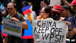 菲律宾渔民和活动人士在中国驻马卡蒂领事馆前举牌抗议中国海警执法新规。（2024年6月11日）