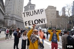 美国前总统特朗普的反对者在纽约法院外举牌反对特朗普。（2023年4月4日）