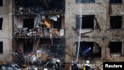 Firefighters works at the site of a residential building heavily damaged during a Russian missile attack in Kyiv on January 2, 2024. (Valentyn Ogirenko/Reuters)