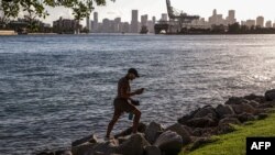 A man walks among the rocks of South Point Park in Miami Beach, Florida, during a heat wave in the U.S. on June 26, 2023. 