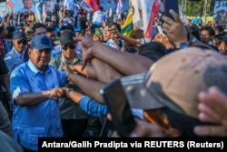 Menteri Pertahanan sekaligus calon presiden Prabowo Subianto menyapa pendukungnya saat kampanye di Stadion Baharoeddin Siregar, Deli Serdang, Sumatera Utara, 7 Februari 2024. (Foto: Antara/Galih Pradipta via REUTERS)