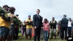 FILE - French President Emmanuel Macron pays tribute to the Kanak tribe of Hwadrilla, where the 19 Kanak militants are buried, on Ouvea Island, off New Caledonia, May 5, 2018. 
