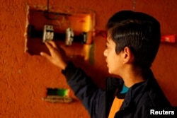 Displaced Palestinian teenager Hussam Al-Attar, nicknamed by people 'Newton', shows an electrical panel at a tent camp in Rafah, in the southern Gaza Strip, February 6, 2024. (REUTERS/Ibraheem Abu Mustafa)