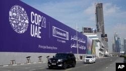 Cars pass by a billboard advertising COP28 at Sheikh Zayed Highway in Dubai, United Arab Emirates, Nov. 27, 2023.