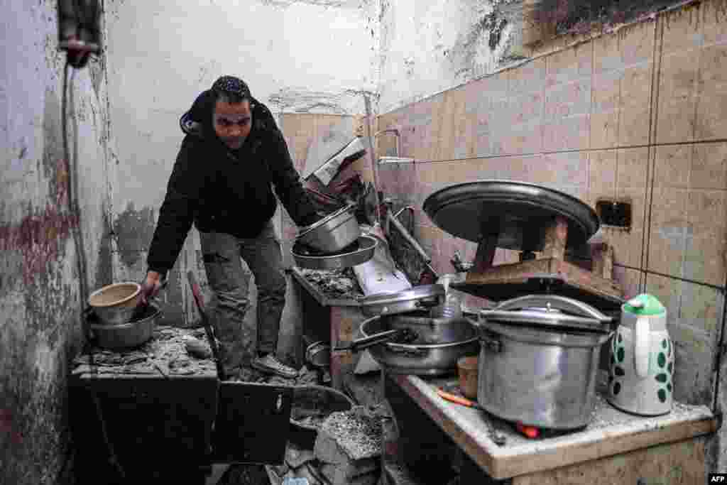 A man salvages kitchen utensils from his damaged home, following overnight Israeli bombardment in Rafah in the southern Gaza Strip, Feb. 25, 2024,