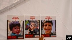 Poster berisi wajah anak-anak Israel yang dijadikan sandera oleh Hamas terpampang di sebuah area di Tel Aviv, pada 21 November 2023. (Foto: AP/Ariel Schalit)
