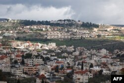 Desa Turmus Ayya dekat kota Ramallah menunjukkan latar belakang pemukiman Shilo Israel di dekatnya, di Tepi Barat yang diduduki pada 18 Februari 2024. (Foto: AFP)