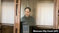In this photo released by the Moscow's City Court, Wall Street Journal reporter Evan Gershkovich stands in a glass cage in a courtroom at the Moscow City Court in Moscow, Feb. 20, 2024. (Moscow City Court via AP)