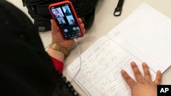 미국 버지니아주 알렉산드리아 시내 마트 근무자가 휴식 시간에 스마트폰으로 영어 강의를 듣고 있다. (자료사진)