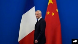 French Finance Minister Bruno Le Maire walks past the French and Chinese flags at the 9th China-France High Level Economic and Financial Dialogue held at the Diaoyutai State Guest House in Beijing, July 29, 2023. 