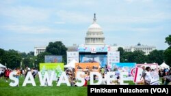 People walk past a sign 'Sawasdee' or Hello in Thai during the Sawasdee DC Thai Festival 2023.