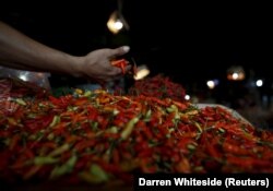 Seorang penjual cabai sedang memilah hasil panennya di kiosnya di pasar tradisional Jakarta, 4 Juni 2015. (Foto: REUTERS/Darren Whiteside)