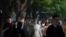 Commuters, many wearing face masks, walk along a street in the central business district during the morning rush hour in Beijing, May 26, 2023.