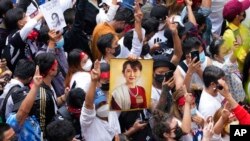 FILE - Myanmar nationals living in Thailand hold a picture of former Myanmar leader Aung San Suu Kyi during a protest marking the two-year anniversary of Myanmar's military takeover, in Bangkok, Thailand, Feb. 1, 2023.