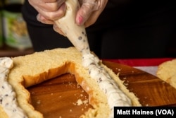 A cannoli king cake is made during Mardi Gras 2021 at Nor-Joe's Importing Company, an Italian grocery in New Orleans.