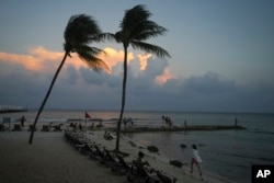 People lounge on the beach as the sun sets ahead of Hurricane Beryl's expected arrival, in Playa del Carmen, Mexico, July 3, 2024.