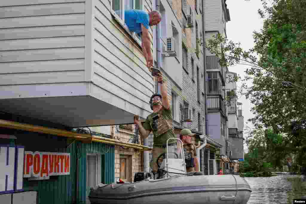Serhii, a local resident who lives in a flooded house, receives humanitarian aid after the Nova Kakhovka dam breached, in Kherson, Ukraine, June 7, 2023.