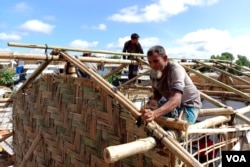 Two Rohingya men build a house inside Jamtoli refugee camp, Cox’s Bazar, Bangladesh, on Aug. 28, 2023. The refugees live in flimsy bamboo and plastic sheet shanties. (Noor Hossain for VOA)